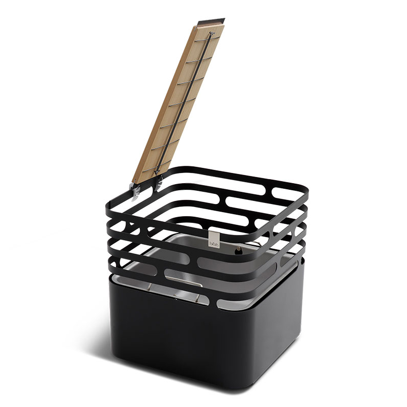 Ein schwarzer Feuerkorb, der Cube, und ein Holzbrett mit einem Rost, um einen Lachs zum Grillen zu halten und ein Rabattsymbol. Das Flammen-gegrillte Lachs-Brett wird gezeigt.