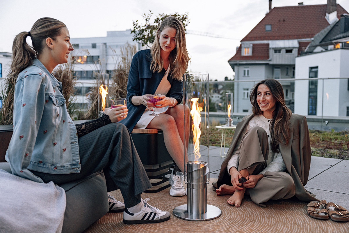 SPIN 1500 Pied d`Élévation argent Deux femmes assises sur un banc, enrichies par la présence du 00629 SPIN 1500 élévation en argent, qui allie design et utilité.