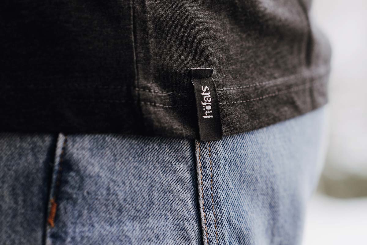 Ici est représenté un homme portant un SHIRT noire et un jean, avec le SHIRT Men gris en taille S.