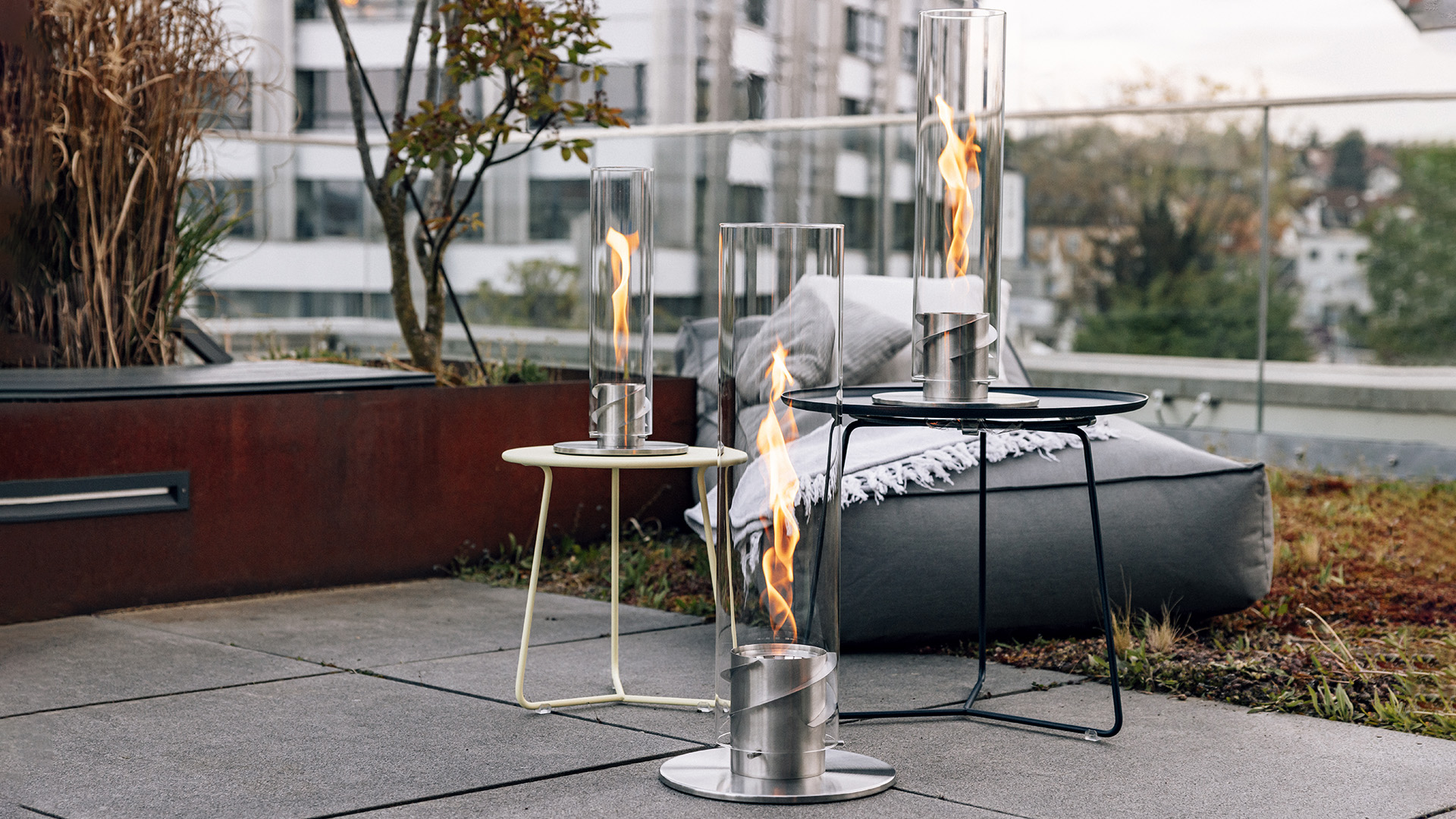 A depiction of a fire pit with a fire burning in it, featuring the 00509 Spin 1500 Tablefire silver as a central and purposeful element.