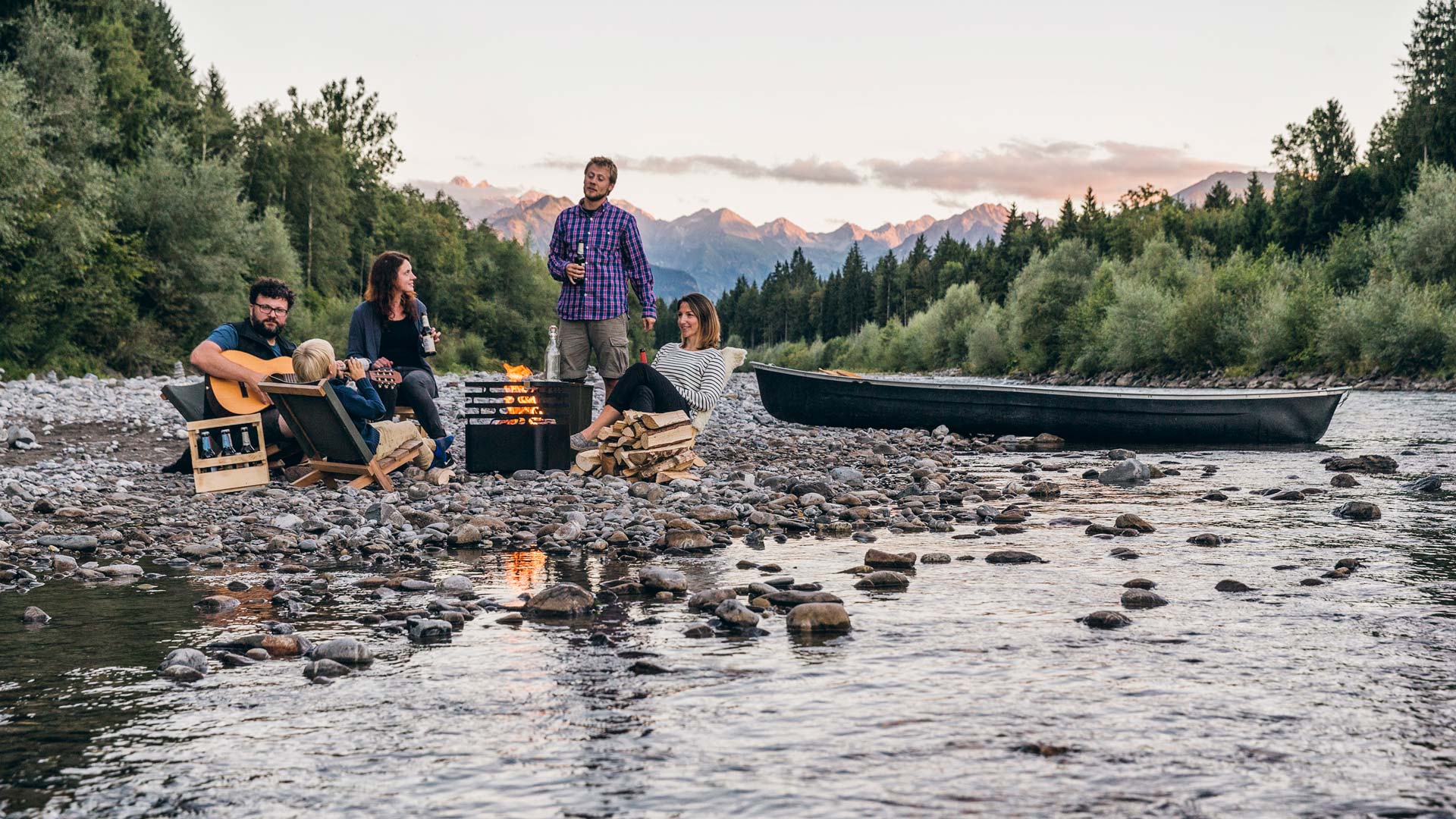 The Cube Cover integrates seamlessly into the setting, where a group of people sitting on rocks in the river.