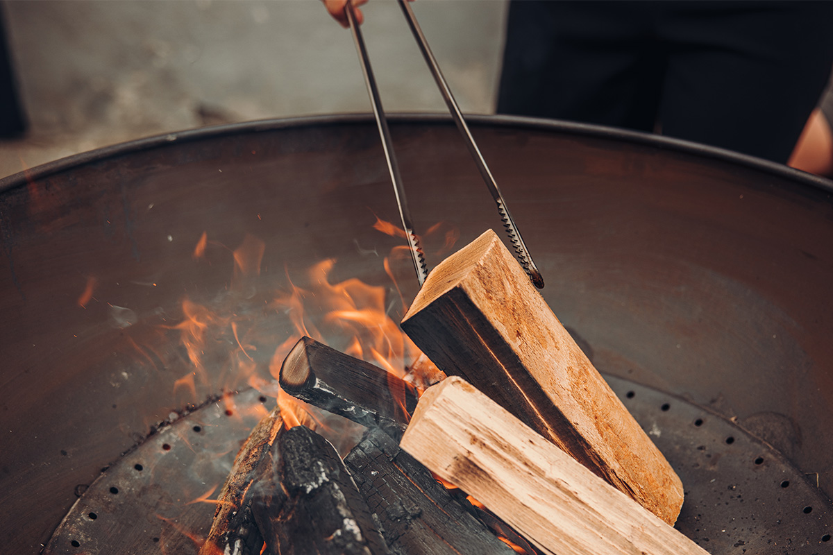 Fire Tools Set 3 pcs A person is cooking something on a fire the 00251 Fire Tools Set 3 pcs complements the moment with its thoughtful design.