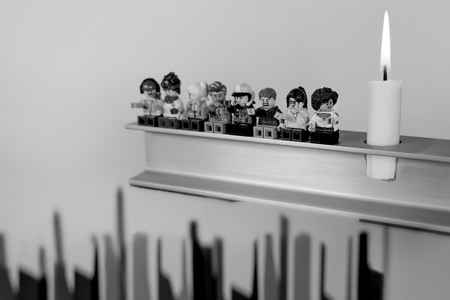 Een kaars en Legostenen op een plank.