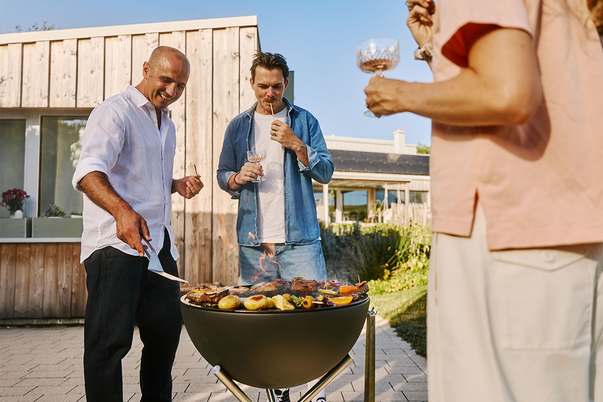 BOWL 57 Plancha-grillset laag De 00256 Bowl 57 Plancha integreert naadloos in de omgeving, waar iemand vlees aan het grillen is.