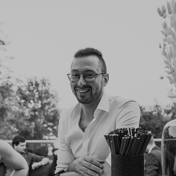 Ein Mann sitzt an einem Tisch mit einem Getränk.