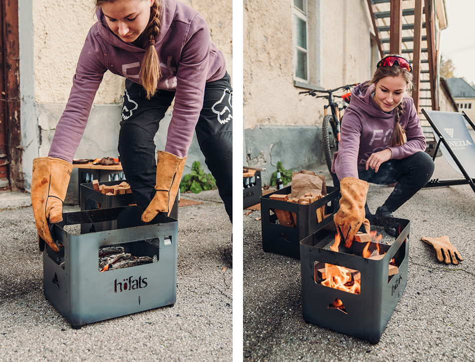 Sur l'image, une femme met le feu dans une boîte avec le Brasero BEER BOX.