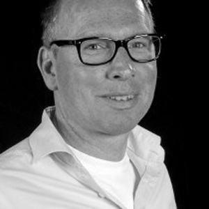 Ein Mann mit Brille und einem weißen Hemd.