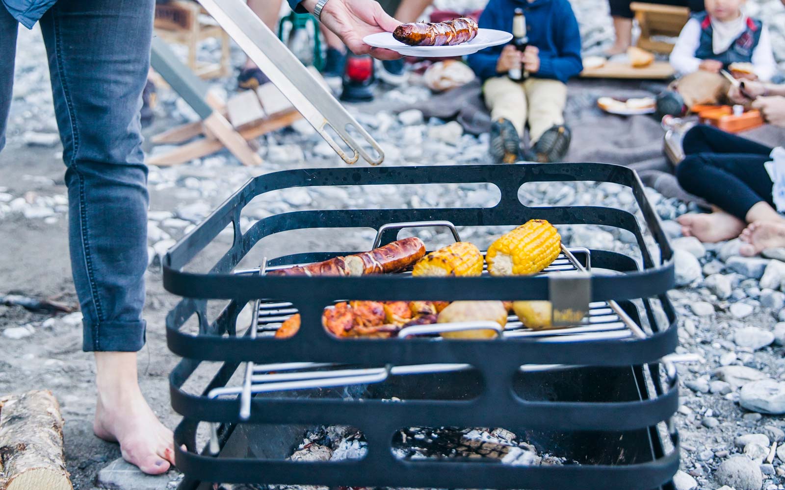 CUBE BBQ Set black Scene showing a person is grilling food on a grill, where the Cube Bbq Set stands out for its practical elegance.
