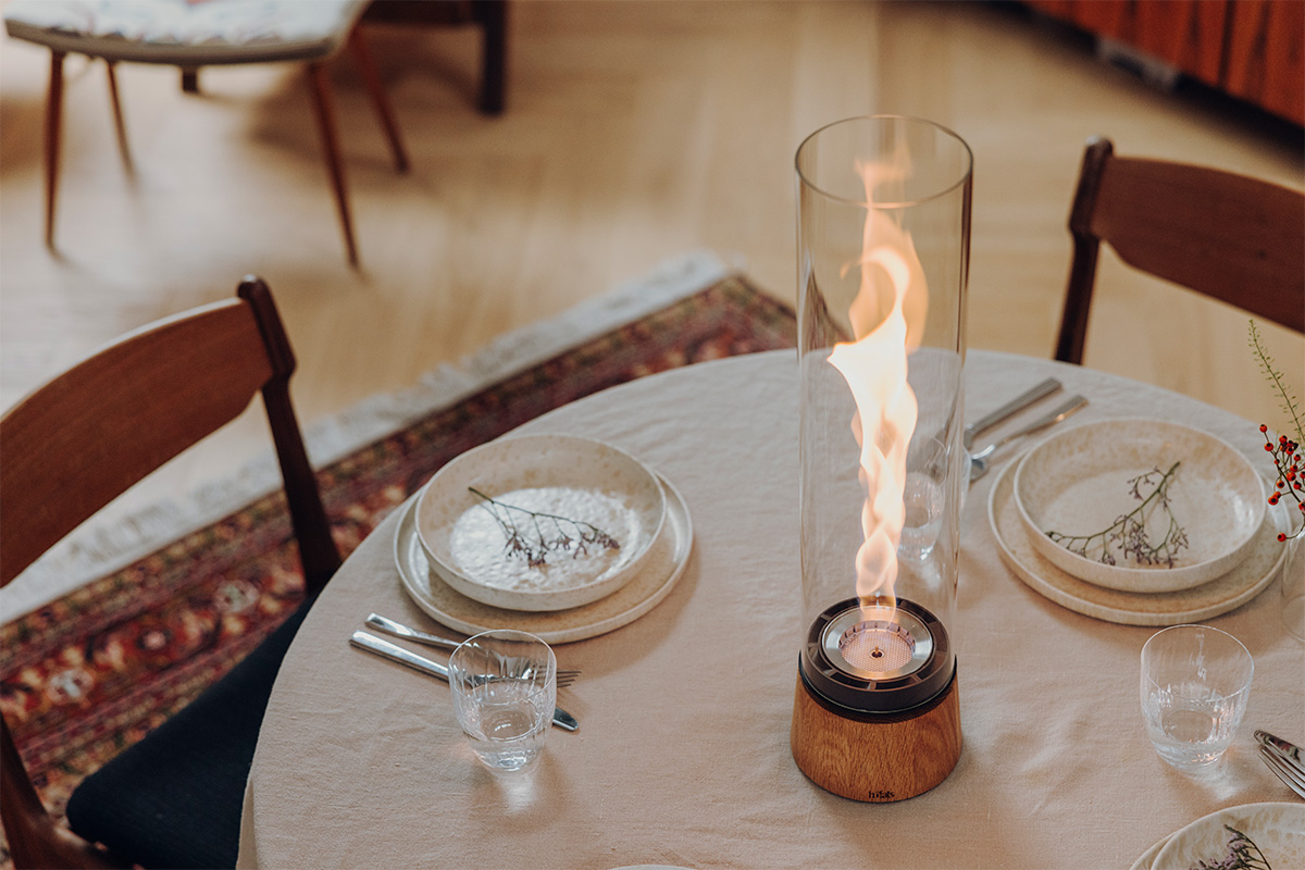 SPIN air 1200 Tischfeuer Eiche SPIN air 1200 Tischfeuer Eiche an einem runden gedeckten Tisch