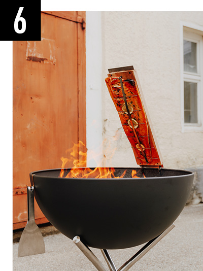 a fire pit with a burning stick sticking to it.