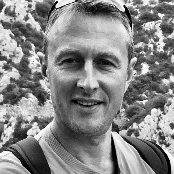 Ein Mann mit einem Rucksack lächelt in die Kamera