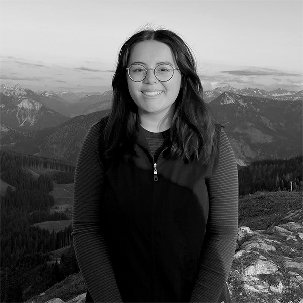 Eine Frau steht auf dem Gipfel eines Berges