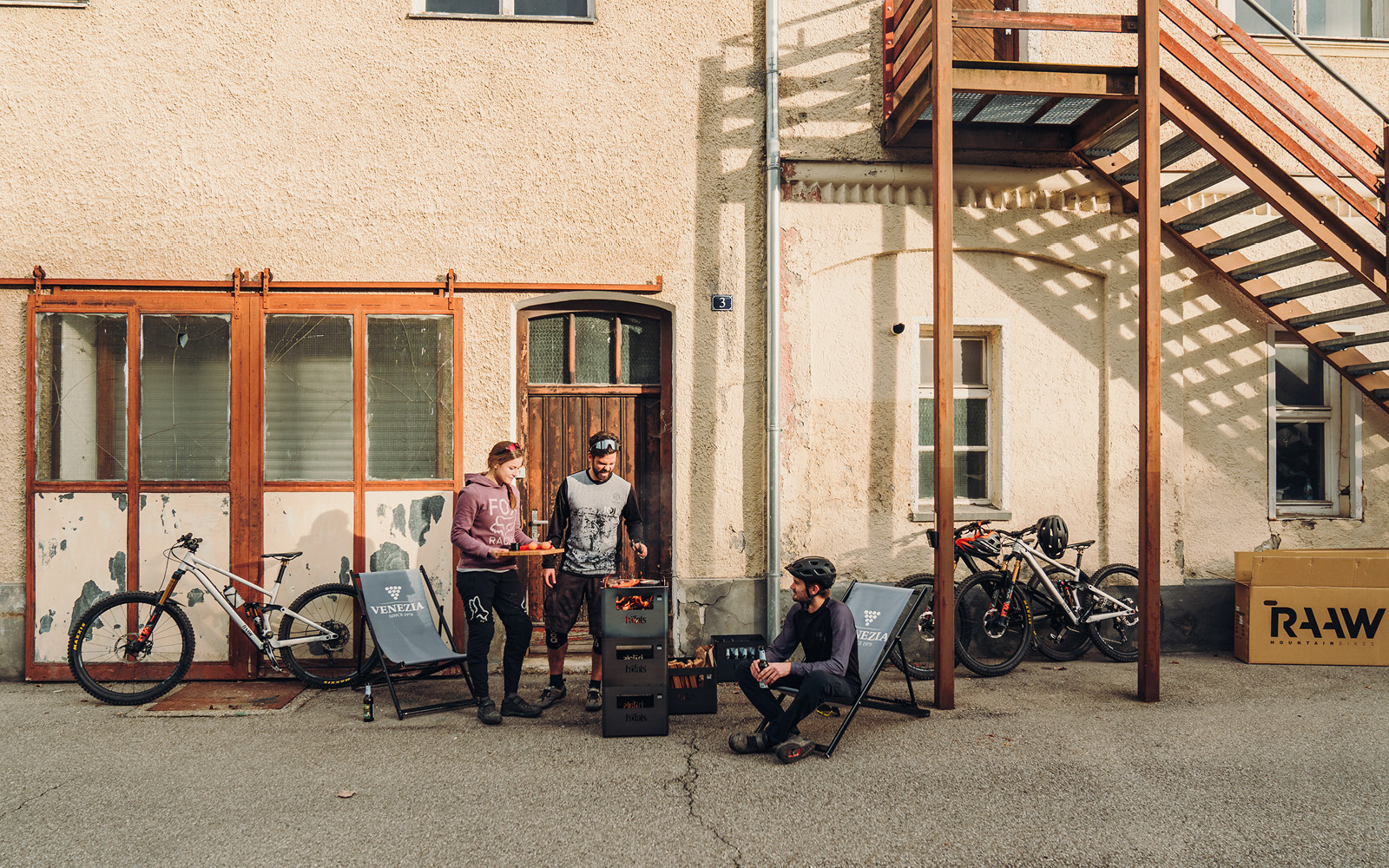 Illustré est un homme assis sur une chaise devant un bâtiment, avec le brasero BEER BOX.