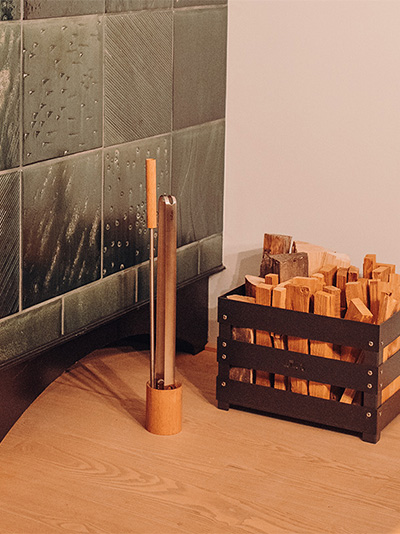 Abgebildet ist hier ein Bett mit einem Holzkopfteil, mit dem Kaminwerkzeug-Set 3-teilig.