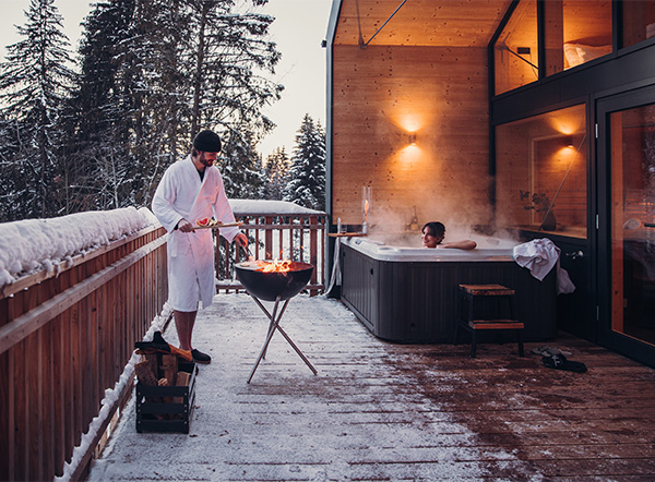 A man standing on a balcony next to a whirlpool. Grilling on the BOWL 57.