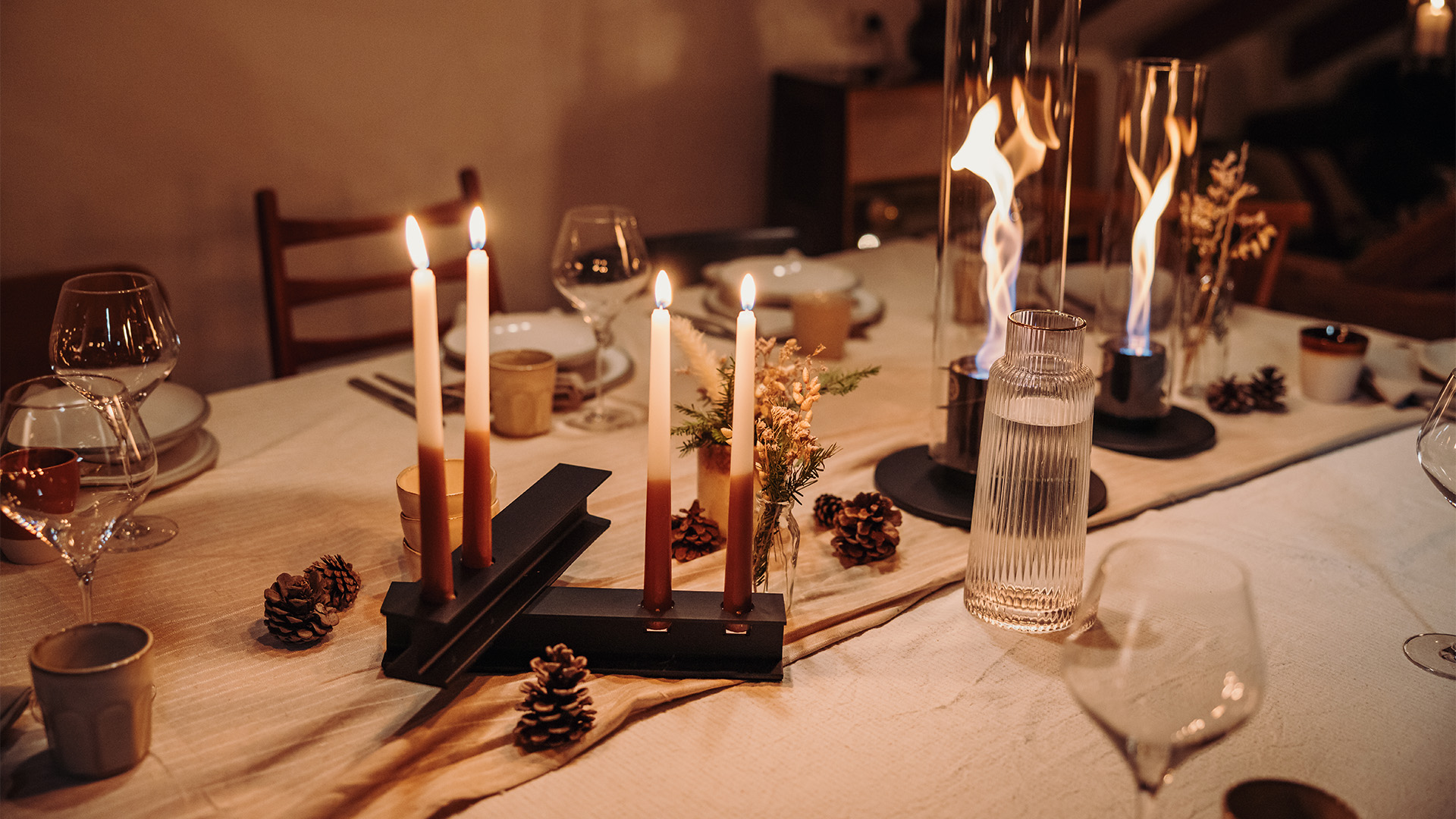 Une représentation d'une table de dîner avec des bougies et des bougeoirs, mettant en vedette le HENRY METAL II noir comme élément central et intentionnel.
