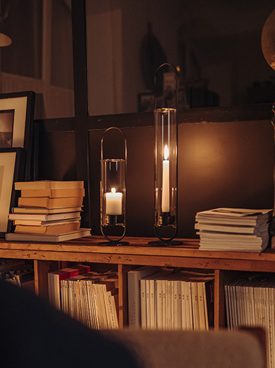 Scène waarin een donkere kamer 's avonds alleen verlicht wordt door het licht van de OVAL Candle, die opvalt door zijn praktische elegantie.