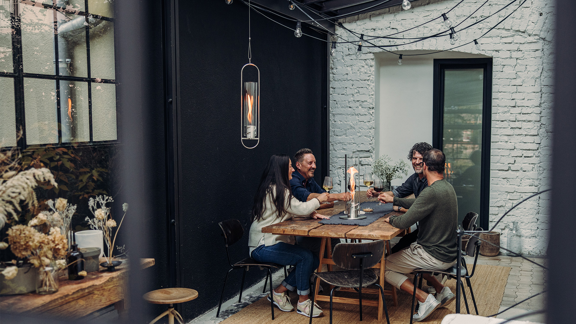 An inviting scene with a couple sitting at a table in a restaurant, highlighted by the presence of the Spin 900 Hanging Fire