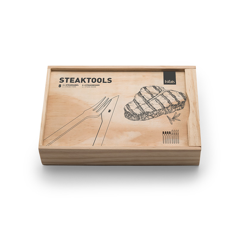 Steakbesteck Ein Blick auf eine Holzkiste mit einer Zeichnung eines Steaks, mit den TOOLS Steaktools.