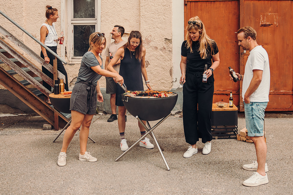 BOWL 70 Vuurset flex Hier is een groep mensen afgebeeld die rond een grill staan, met de BOWL 70 driepoot.
