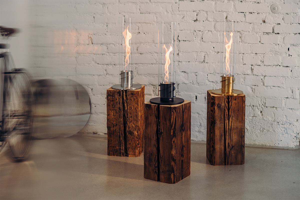 SPIN 1200 Tabletop Fireplace gold Scene showing a couple of candles sitting on top of a table, where the 00699 Spin 1200 Tablefire Gold stands out for its practical elegance.