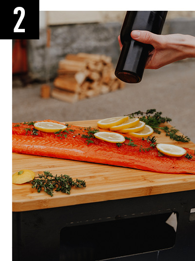 A depiction of a person adding spices to a salmon