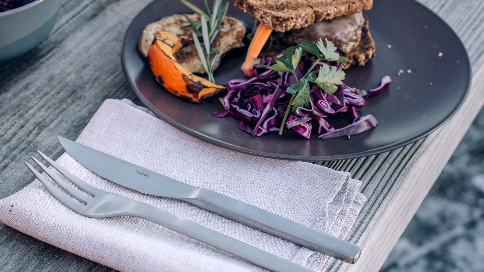 Abgebildet ist ein Teller mit einem Messer und etwas Essen