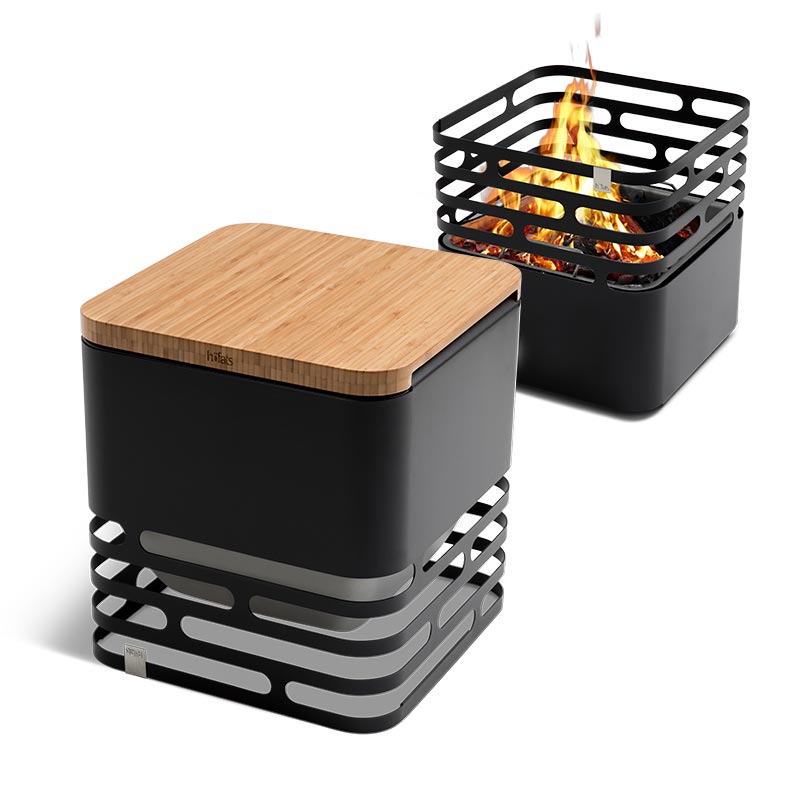 CUBE Flip Set schwarz Ein schwarzer Stahlgrill mit einem Holzbrett oben drauf auf weißem Hintergrund, das Cube Flip Set