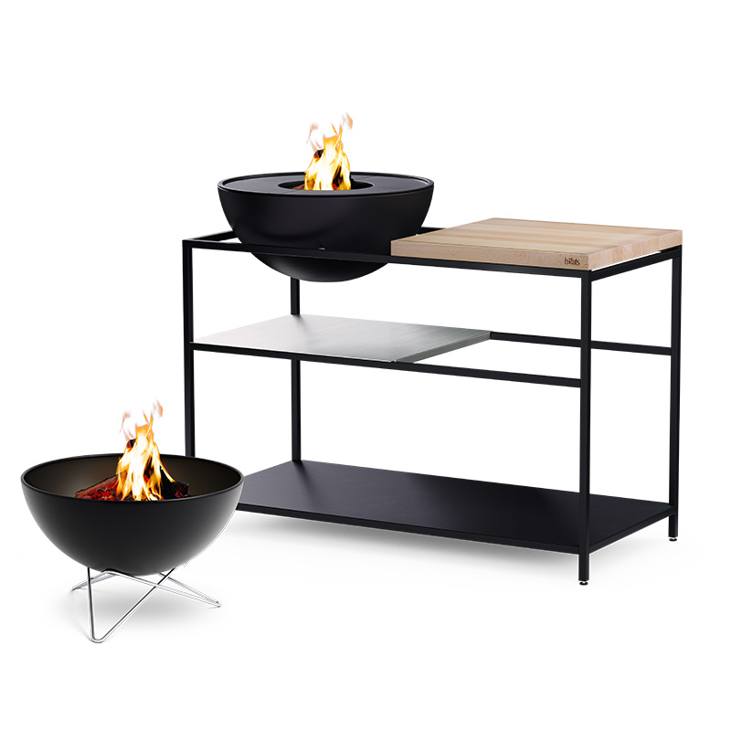 FIRE KITCHEN with BOWL 57 Plancha BBQ Set low A view of a fire pit and a bowl on a table, with the FIRE KITCHEN with BOWL 57 Plancha BBQ Set incl. wheels.