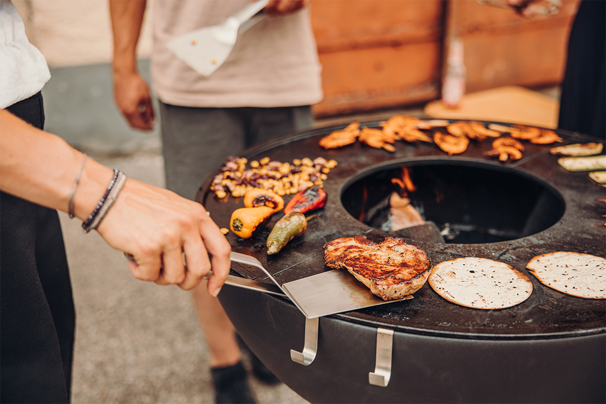 BBQ Tool Set (3 pcs) This image shows a person is cooking food on a grill, with the .