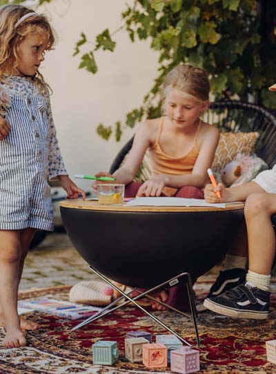 Ein kleines Mädchen sitzt mit seiner Mutter auf einem Teppich