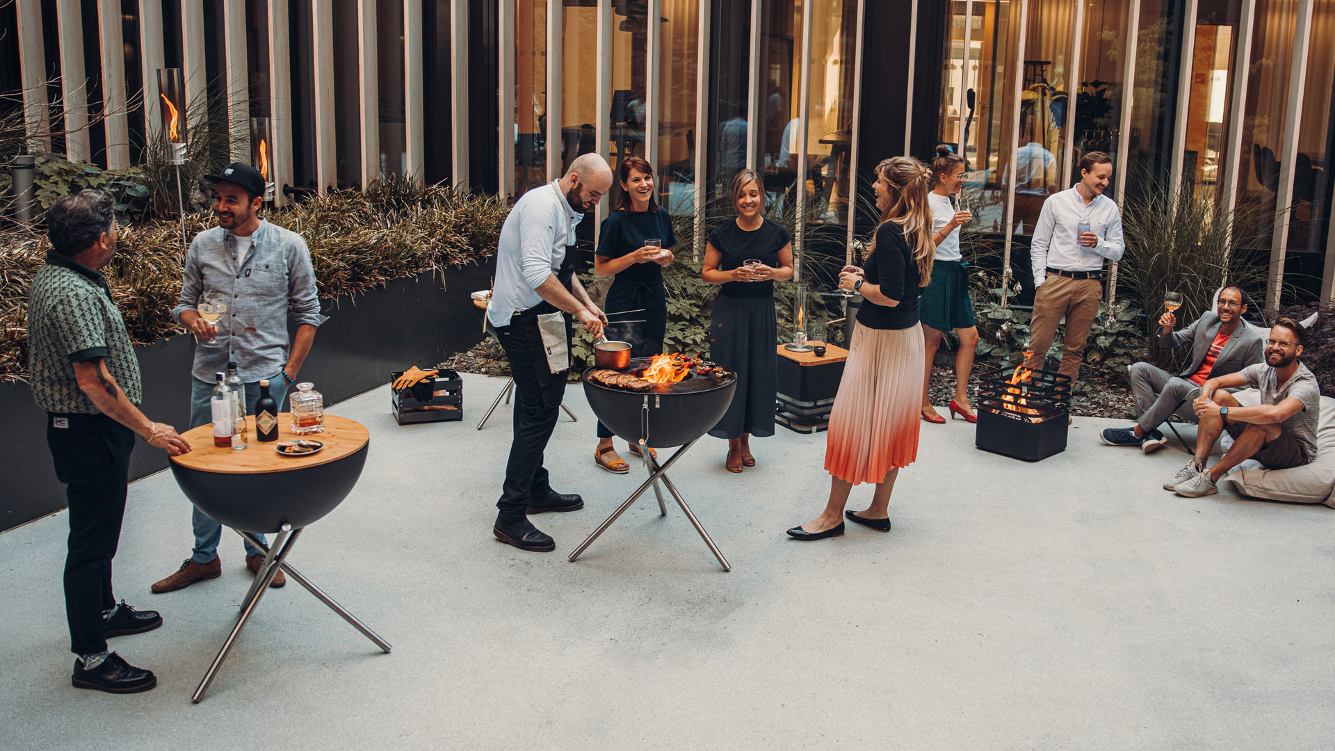 Découvrez un groupe de personnes debout autour d'une table avec la touche raffinée du BOWL 70 avec Trépied 00258.