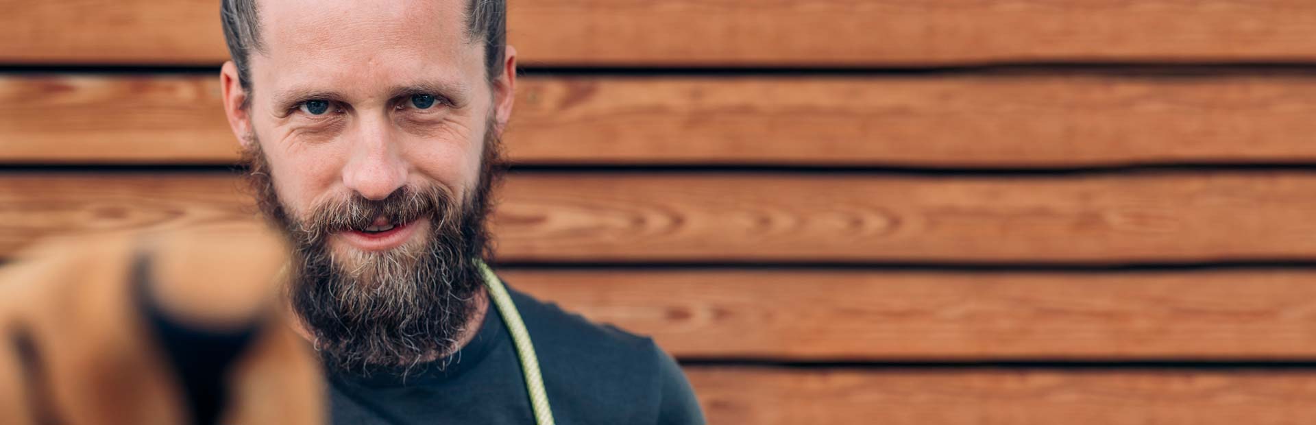 Een man met een baard en een zwart shirt.