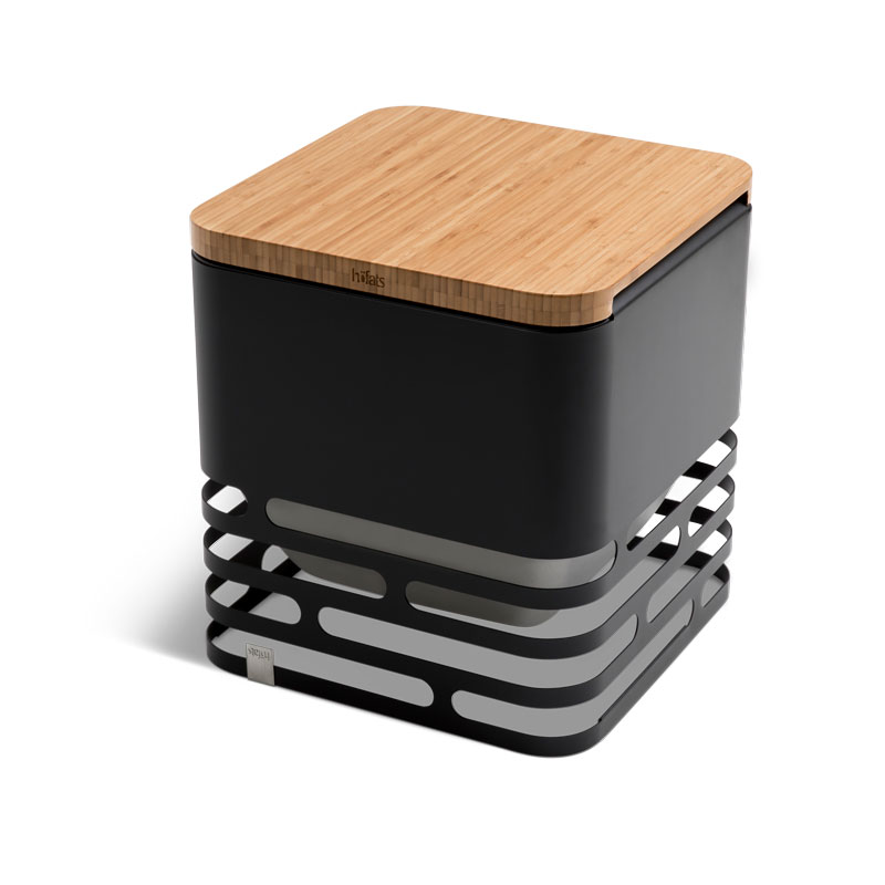 CUBE Flip Set schwarz Ein schwarzer Stahlgrill mit einem Holzbrett obendrauf auf weißem Hintergrund, das Cube Flip Set
