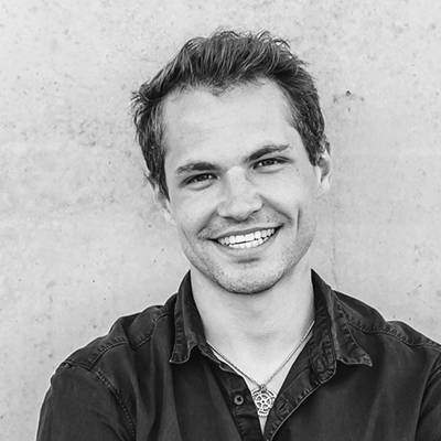 Ein Mann in einem schwarzen Shirt und Jeans