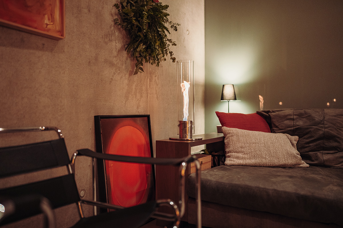 SPIN 1200 Tabletop Fireplace silver A depiction of a living room with a couch and a table, featuring the 00695 Spin 1200 Tablefire silver as a central and purposeful element.