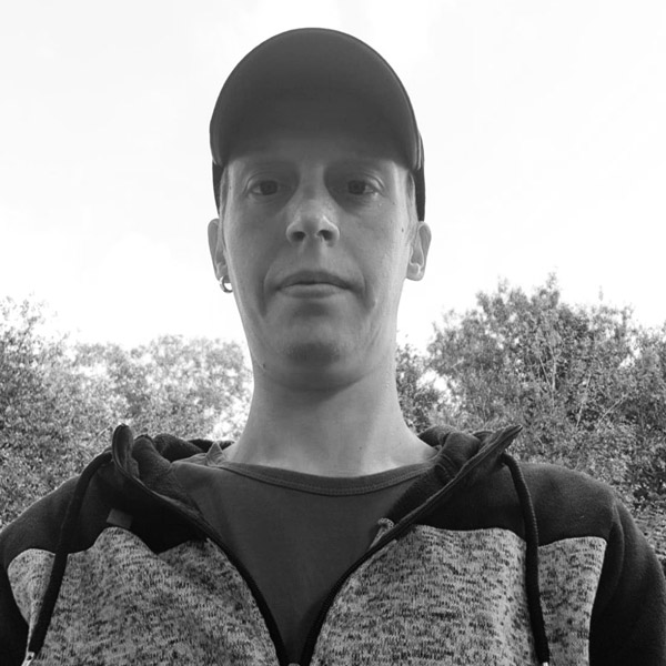 Ein Mann mit Baseballkappe und Pullover.