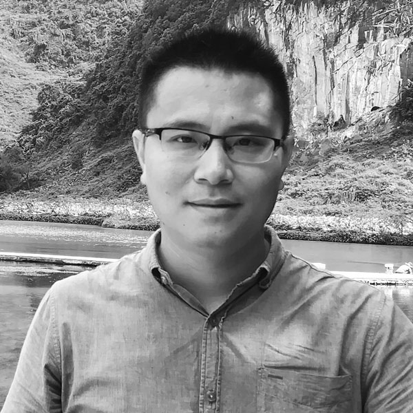 Ein Mann mit Brille steht am Strand.