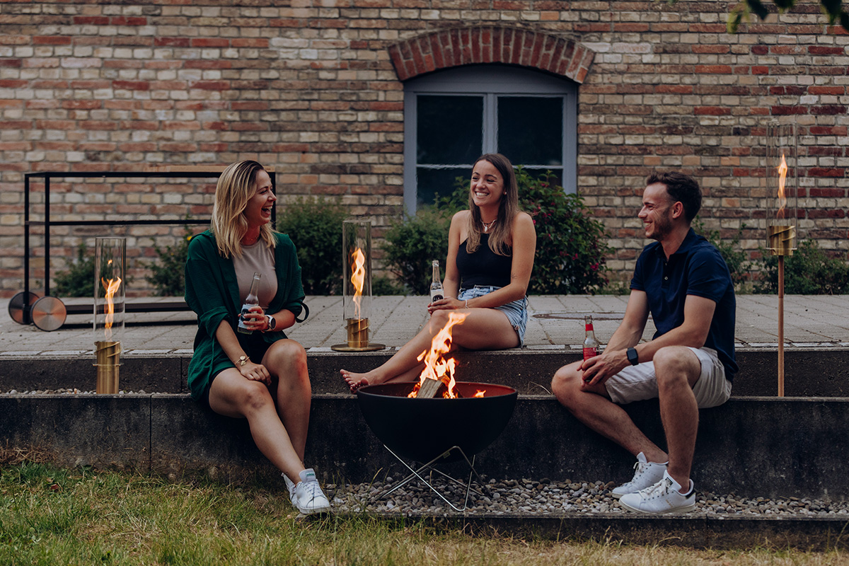 Ein Mann und eine Frau sitzen auf einer Mauer mit einem Feuer.