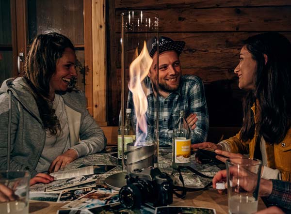 Mountain hut magic Depicted here is a group of friends sitting around a table at a restaurant, with the SPIN 120 Table Fire silver.