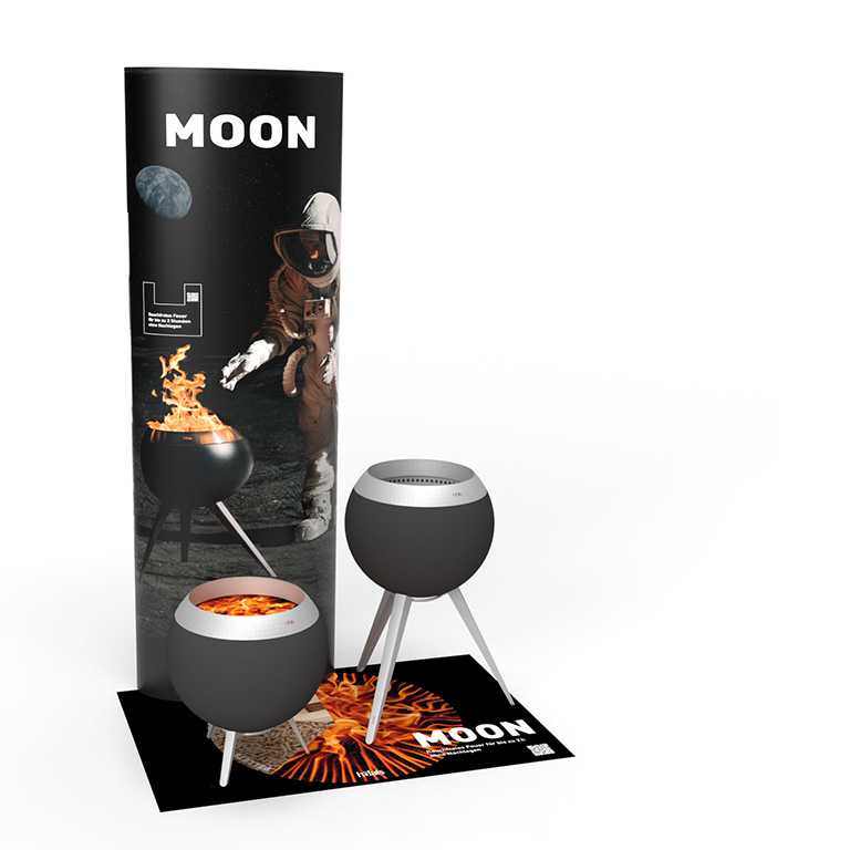 Een kartonnen kolom met een astronaut erop en een tapijt met twee varianten van de MOON 45. Toont de MOON POS Set.