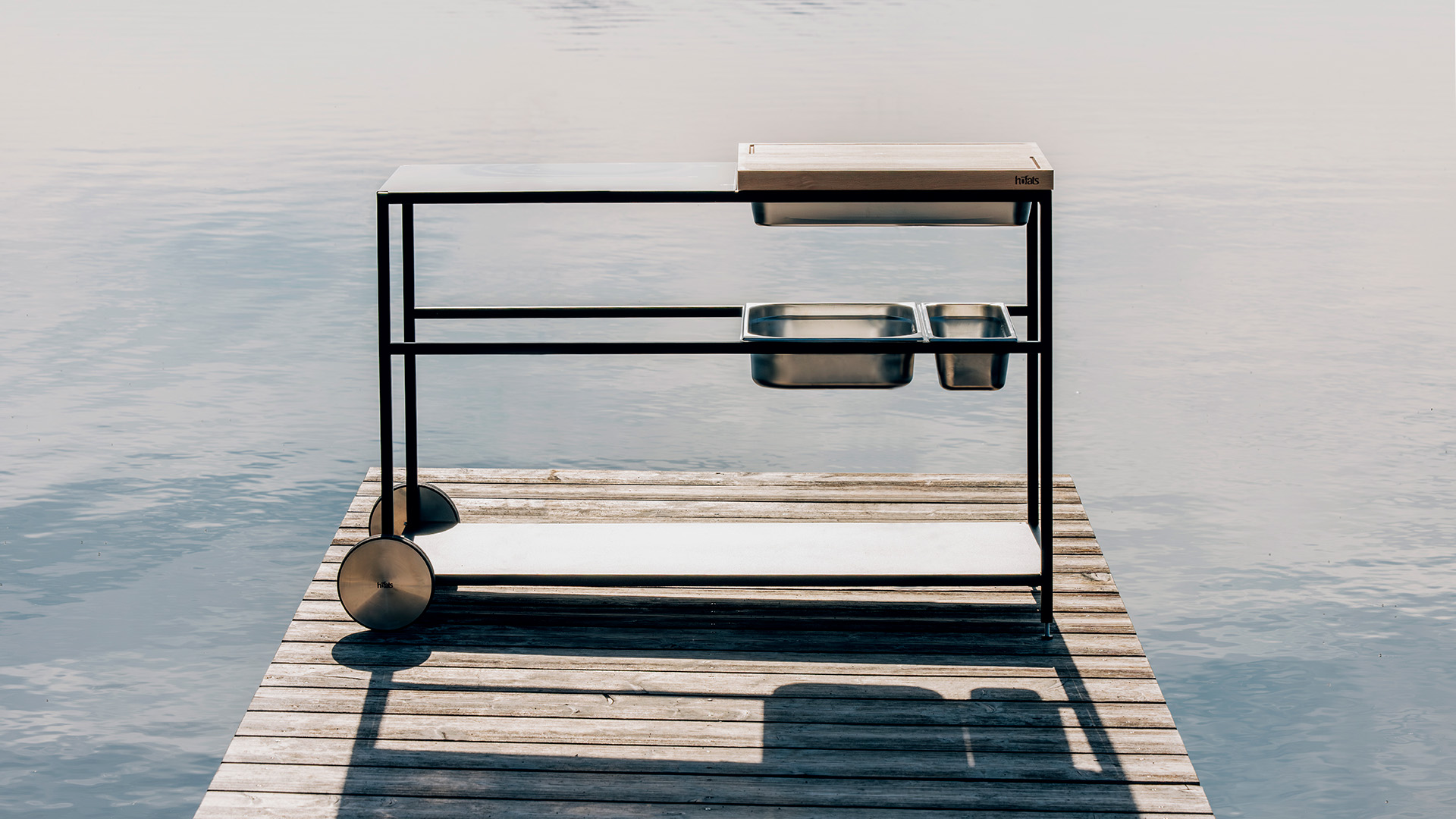 Ein Bild zeigt einen Grill auf einem Steg im Wasser, mit der FIRE KITCHEN Outdoor-Küche.