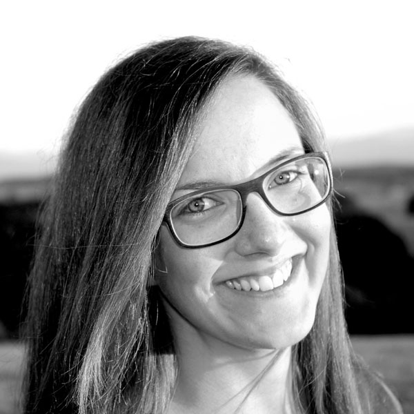 Eine Frau mit Brille lächelt in die Kamera.