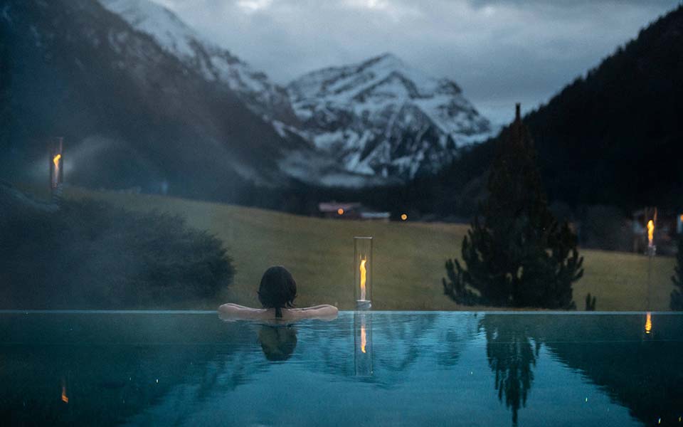 The photo presents a woman in a pool with mountains in the background, with the Atmospheric image Christmas for Console.