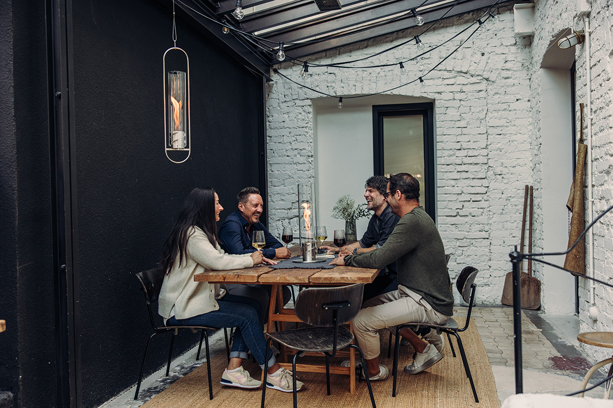 An inviting scene with a couple sitting at a table in a restaurant, highlighted by the presence of the Spin 900 Hanging Fire