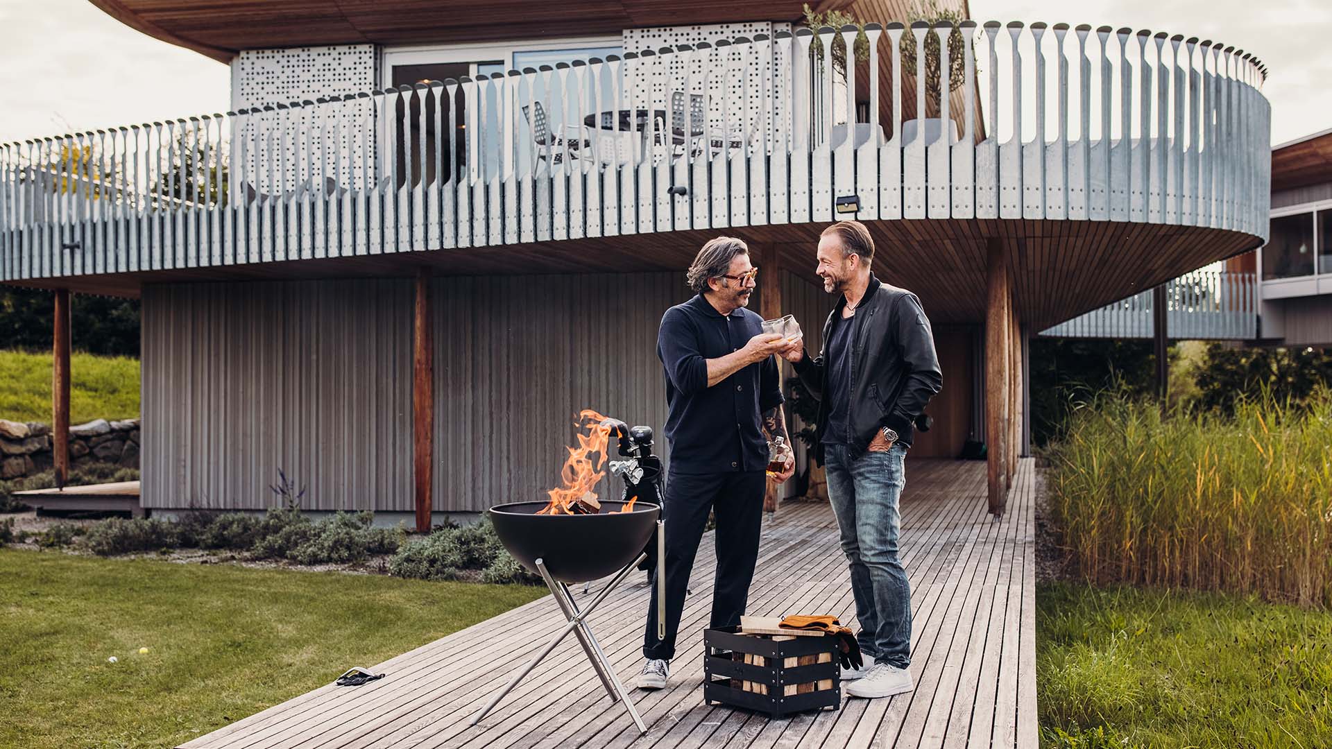 The 00342 Bowl 57 Tripod is shown as two men grilling outside a house, creating a stylish and accessible visual.
