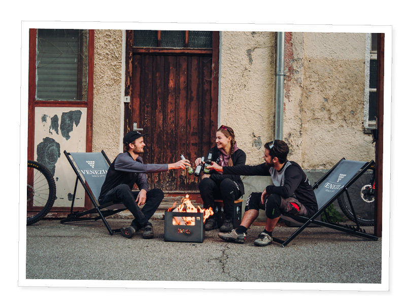 a couple of people sitting around a fire pit.