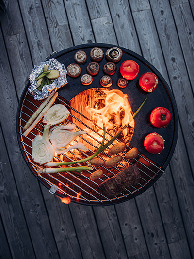 Das Foto zeigt einen Grill mit Essen darauf, mit dem BOWL Grillrost.
