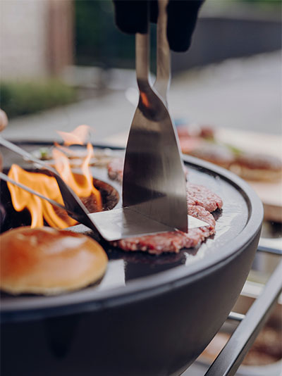 Depicted here is a person is grilling a hamburger on a grill