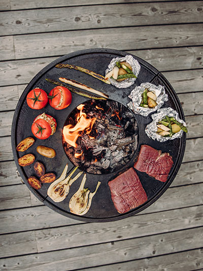 Ein Grill mit Fleisch und Gemüse darauf.